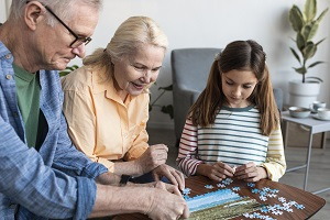 puzzle s kresleným obrázkem domu, auta a rodiny